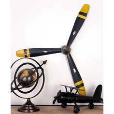 an airplane propeller sitting on top of a wooden table next to a small toy plane