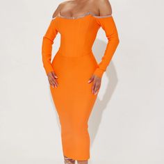 a woman wearing an orange dress with long sleeves and high heels, posing for the camera