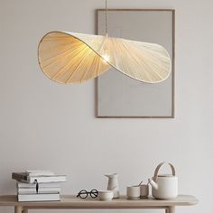 a wooden table topped with white vases next to a mirror and framed art on the wall