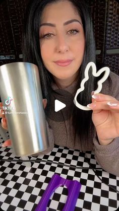 a woman holding a cup and scissors in front of her with the word love spelled on it