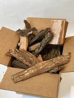 a cardboard box filled with cut up pieces of driftwood sitting on top of each other