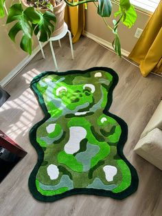 a green rug on the floor in front of a chair and potted plant next to it