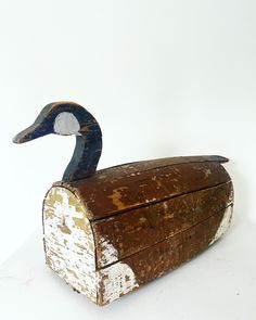 an old wooden box with a painted duck on the top and bottom, sitting on a white surface