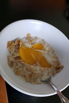 an oatmeal with orange slices and milk in a white bowl