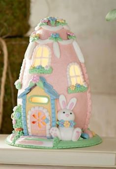 a cake shaped like a pink house with lights on it's windows and door