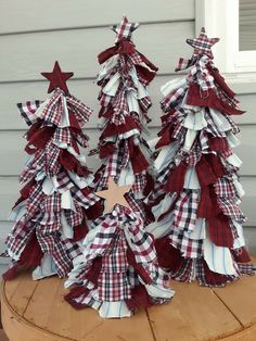 three red and white christmas trees sitting on top of a wooden table