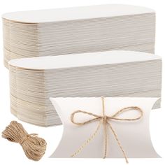 two white boxes tied with twine and one box has a bow on the front