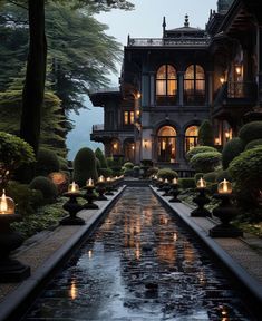 a large house with lots of windows and lit candles in front of the water fountain