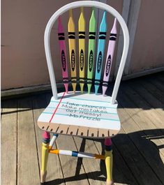 a wooden chair with crayons painted on it