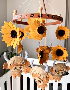 a crib with sunflowers and stuffed animals hanging from it