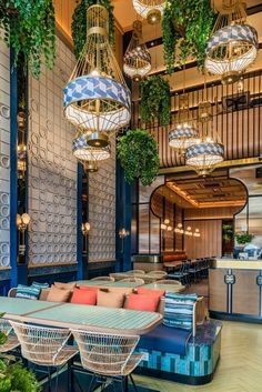 an indoor restaurant with hanging plants and wicker chairs