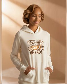 a woman wearing a white hoodie that says tea and coffee day ahead on it