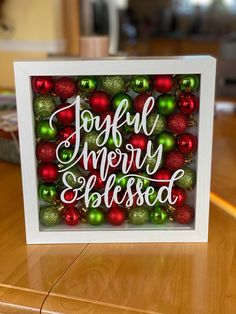 a christmas card that says joyful merry and filled with baubles on a table