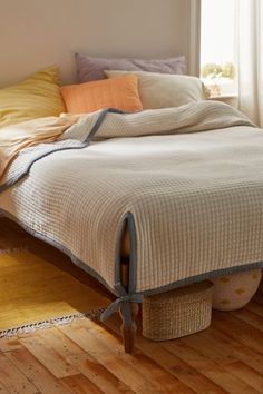 a bed sitting on top of a wooden floor next to a window