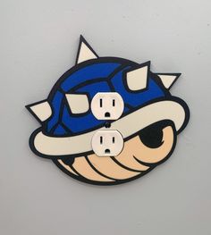 two power outlets are attached to a wall with a cartoon character wearing a baseball hat