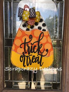 a trick or treat door hanger with polka dots and an orange pumpkin on it