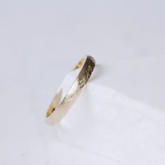 a gold and silver ring sitting on top of a white surface