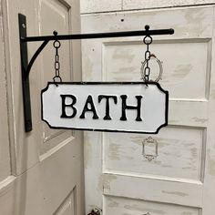 a bath sign hanging from the side of a door