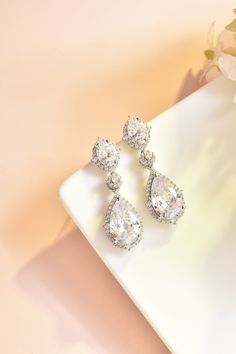 "These stud bridal earrings are stunning for bridal occasions whether you want a vintage or classic look. These beauties are designed with encrusted crystals and high quality AAA+ cubic zirconia that glistens on the ear. They come in a sparkling silver, gold or rose gold finish to give an elegant look. These gorgeous earrings will be carefully wrapped and arrive in a logo gift box. Visit my shop for care instructions and more bridal accessories ➔ https://www.etsy.com/shop/BlushandIvoryStudio Mea Luxury Sterling Silver Bridal Earrings, Exquisite Style, Luxury Pear-shaped Cubic Zirconia Bridal Earrings, Pear-shaped Cubic Zirconia Chandelier Earrings For Wedding, Evening Bridal Earrings, Cubic Zirconia Dangle, Silver Bridal Earrings With Rhinestones, Cubic Zirconia, Long Bridal Earrings, Bridal Statement Earrings, Meaningful Necklace, Bridal Earrings Chandelier