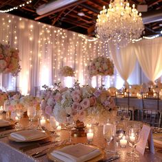 a table with candles, flowers and napkins is set up for a formal function