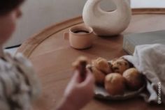 a person sitting at a table with some food and a vase on top of it