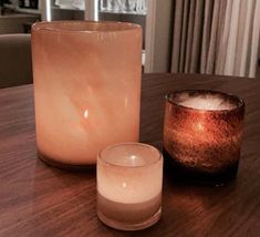 two candles sitting on top of a wooden table