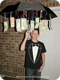 a young boy holding an umbrella with money notes attached to it and hanging from the ceiling