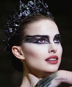 a woman with black makeup wearing a tiara