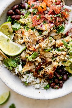 a white bowl filled with rice, black beans and vegetables