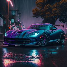 a blue sports car parked on the side of a road in the rain at night