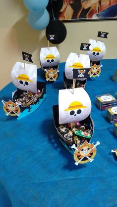 a table topped with lots of pirate boats and boxes filled with items on top of it