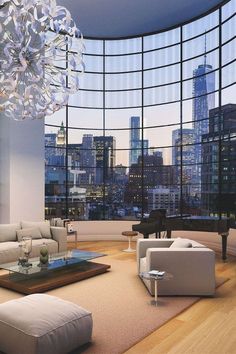 a living room filled with furniture and large windows overlooking the cityscape at night