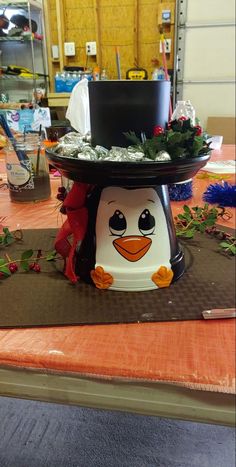 there is a cake with a penguin on it and flowers around the base that have been placed on top