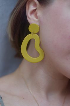 This is a pair of large statement earrings in a beautiful marigold yellow. *Please note because this color is hand mixed, slight variation occurs from batch to batch. Your particular pair of earrings may look slightly different from what is pictured, but that's because it's a unique handmade item made specially for you! These earrings are crafted using polymer clay, a surprisingly lightweight material that won't weigh you down. Each earring is carefully sanded and smoothed to ensure a well-made Modern Yellow Earrings For Everyday, Modern Yellow Earrings For Everyday Wear, Trendy Yellow Earrings, Modern Yellow Dangle Earrings, Bold Yellow Drop Earrings, Trendy Yellow Earrings For Everyday, Trendy Yellow Everyday Earrings, Yellow Earrings With Ear Wire For Everyday, Yellow Teardrop Earrings For Everyday