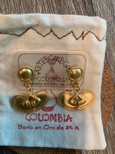 Throughout generations of my Colombian family till this day, we have threaded each bead and shaped every earring into beautiful artisan PreColombian jewelry. Every piece is inspired by at least one part of Colombia's precious nature. Handwoven Brass Dangle Earrings, Handwoven Dangle Brass Earrings, Gold Handwoven Drop Earrings, Handwoven Gold Drop Earrings, Traditional Handwoven Drop Earrings, Traditional Gold Souvenir Jewelry, Traditional Gold Jewelry Souvenir, Traditional Fair Trade Jewelry Gift, Traditional Gold Jewelry For Souvenir