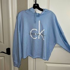 Nwt Calvin Klein Cropped Hoodie Size Is An X-Large. Very Soft Baby Blue With White Ck Lettering Plus “Calvin Klein In Silver Lettering. Very Modern And Classic Light Blue Long Sleeve Hooded Top, Light Blue Long Sleeve Top With Drawstring Hood, Light Blue Sweatshirt For Spring Streetwear, Light Blue Hoodie Sweatshirt For Spring, Light Blue Long Sleeve Athleisure Sweatshirt, Oversized Blue Top With Drawstring Hood, Blue Oversized Top With Drawstring Hood, Light Blue Relaxed Fit Hooded Top, Light Blue Drawstring Hood Sweatshirt For Spring