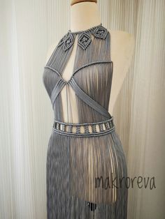 a mannequin wearing a dress with fringes and beads on the neckline