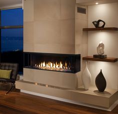 a living room with a fire place in the center and two vases on either side