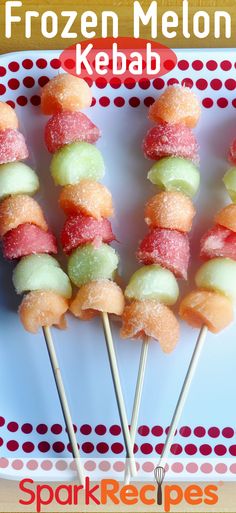 several frozen melon kebabs on a white plate