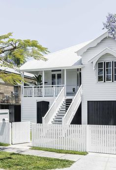 a white house with black shutters and stairs