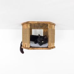 a black cat laying on top of a bed in a wooden structure with white sheets