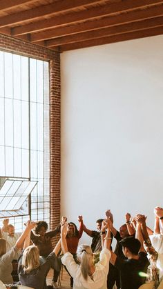 a group of people holding their hands up in the air