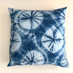 a blue and white tie - dyed pillow sitting on top of a wall