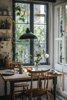 a dining room table with two chairs and flowers in vases on top of it