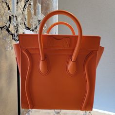 This Orange Handbag Or Tote Bag Has The Same Orange Coloring Similar As The Herms Orange. This Amazing Orange Color Will Coordinate With Any Fashionable Wardrobe. The Spacious Inside Is Incredible. Can Be Used As A Tote Bag Being The Bag's Size Or Just A Handbag. Zipper Closure And A Zipper Pocket Inside. A Small Zipper Pocket On The Front. Height: 10 Length :10 Depth: 5 The Bag Is New With Tags Never Used. I Did Find A Marking Near The Top Zipper Circled In Red. Included Dustbag Luxury Orange Crossbody Satchel, Luxury Orange Bags With Top Carry Handle, Orange Top Handle Bag With Dust Bag, Orange Top Handle Shoulder Bag With Dust Bag, Luxury Orange Shoulder Bag With Double Handle, Designer Orange Shoulder Bag, Luxury Orange Handheld Bag, Luxury Handheld Orange Bag, Luxury Orange Satchel With Detachable Strap