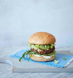 a hamburger with lettuce and cheese on a cutting board