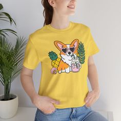 Introducing our Summer Corgi Unisex Graphic Tee – a must-have addition to your warm-weather wardrobe that combines adorable corgi charm with the laid-back vibes of summer! This tee isn't just clothing; it's a fun and stylish way to celebrate your love for these delightful pups and the sunny season. Crafted for both men and women who adore corgis, this tee is perfect for adding a touch of whimsy to your summer look, whether you're lounging at the beach or soaking up the sun by the pool. Featuring a playful corgi graphic and made from high-quality materials for comfort and durability, this tee is sure to become a favorite in your collection. Whether you're a proud corgi lover or searching for the perfect gift for a fellow dog enthusiast, our Summer Corgi Unisex Graphic Tee is guaranteed to b Dog Print Crew Neck Graphic Tee, Summer Dog Print Relaxed Fit T-shirt, Funny Dog Print Crew Neck T-shirt, Summer Relaxed Fit T-shirt With Dog Print, Trendy Crew Neck T-shirt With Dog Print, Relaxed Fit Short Sleeve Tops With Dog Print, Cotton Crew Neck Top With Dog Print, Summer Dog Print Graphic Tee, Summer Dog Print Short Sleeve Top