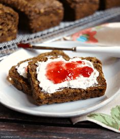 two pieces of bread on a plate with cream cheese and strawberry jam in the middle