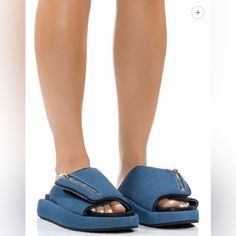 The Azalea Wang Calico Slip On Sandal In Blue Denim Is Made From A Light Denim Upper And Features A Wide, Cushioned Foot Band With Velcro Closure, A Non-Functional Decorative Zipper Detail, A Vegan Leather Insole, A Slip-On Fit, And A Ridged Flatform Sole. *Denim Upper *Open Almond Toe *Flatform Sole *1” Flatform Sole Height Trendy Denim Blue Sandals, Trendy Blue Denim Sandals, Trendy Denim Blue Sandals With Round Toe, Trendy Denim Blue Round Toe Sandals, Denim Blue Platform Sandals In Denim Material, Flat Denim Blue Sandals, Denim Blue Platform Sandals, Casual Denim Slip-on Sandals, Spring Denim Slip-on Sandals