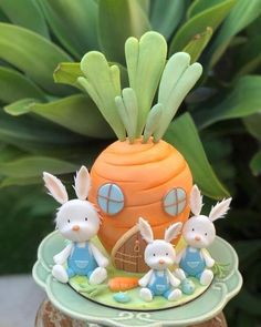 a cake with three bunnies on top of it and some plants in the background